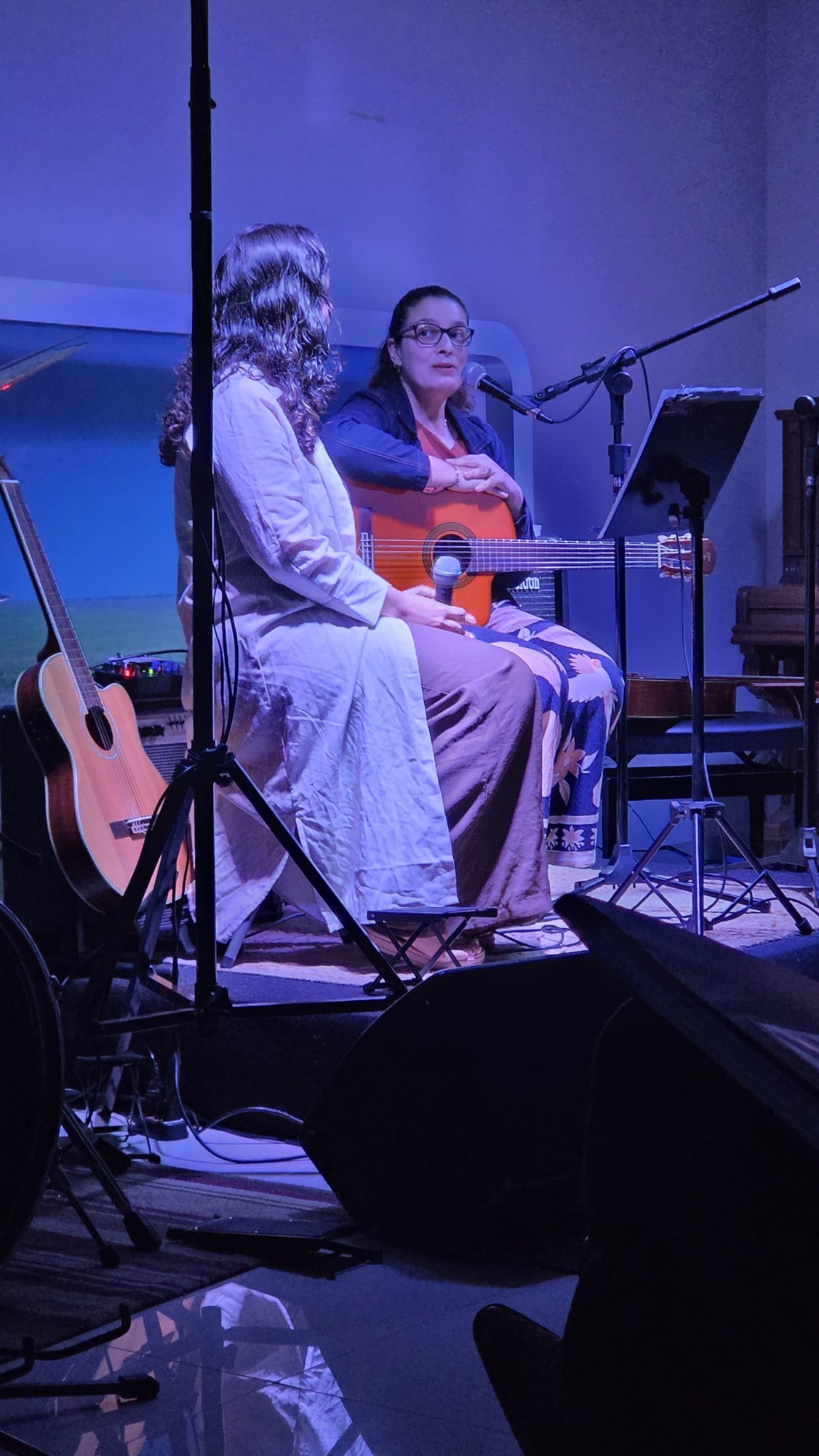 Aluna da Ampli cantando acompanhada ao violão no Festival de Inverno